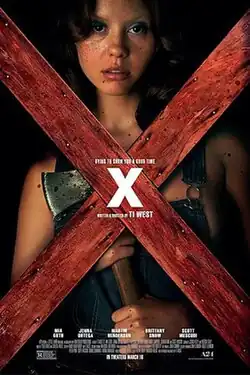 A woman holds a hatchet as she stands behind two red wooden boards nailed together to form an X shape. In the center of the formation, another X is placed, acting as the film's title.