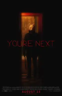 A figure wearing a fox mask stands in a doorway holding a machete by his side