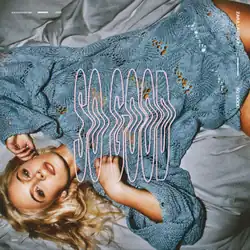 Larsson wearing a blue-green sweater, lying on the bed staring at the screen. In the middle is the album's title "So Good" in pink letters.